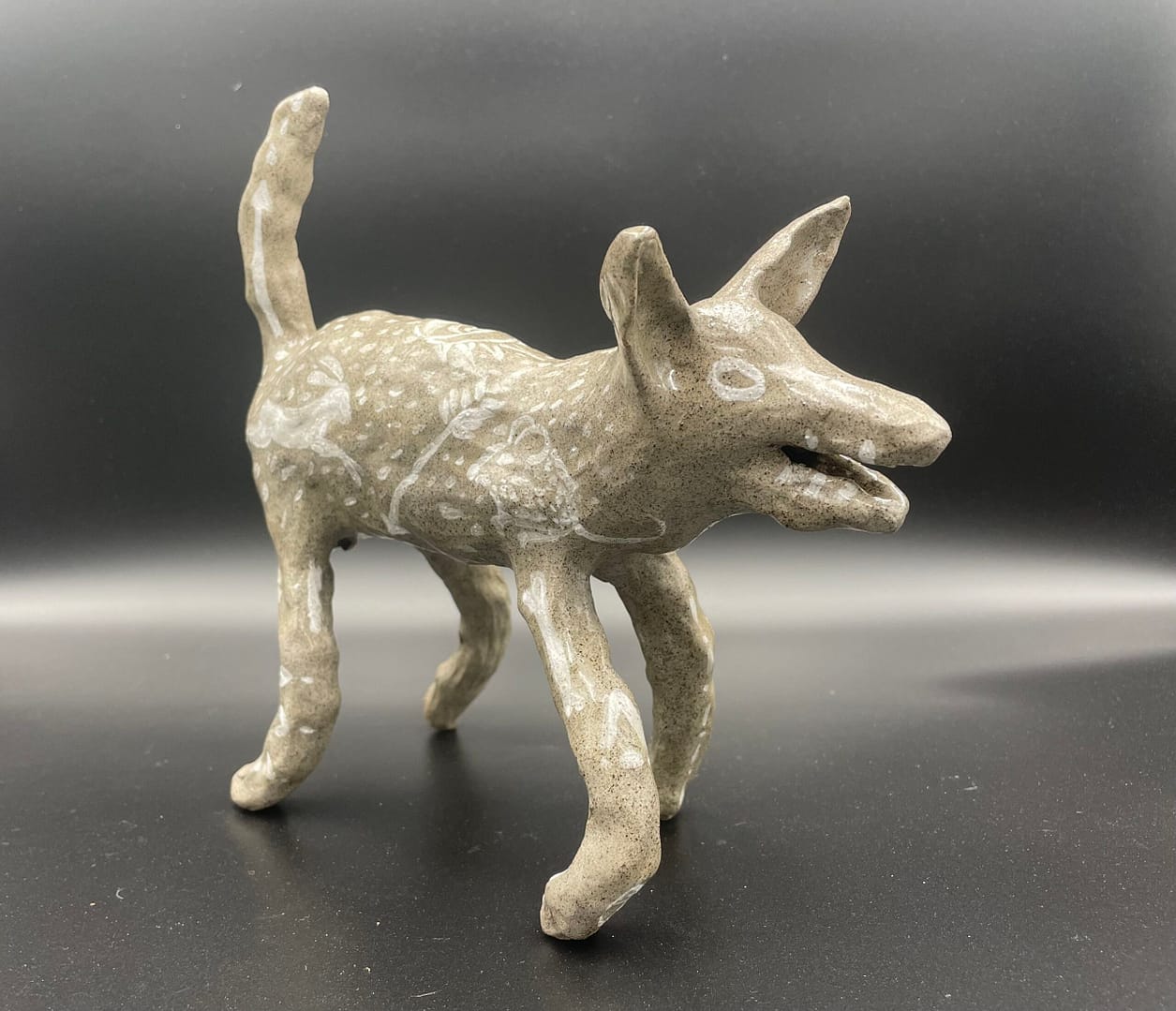 Clara Lundgrens ceramic sculpture depicting a standing dog or wolf, crafted with a swift and playful approach.